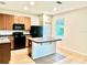 Functional kitchen layout featuring wood cabinets, black appliances, a center island, and tile flooring at 535 Aeolian Dr, New Smyrna Beach, FL 32168