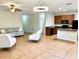 Open-concept living area with tile floors, seamlessly connecting to a kitchen with wooden cabinetry and modern appliances at 535 Aeolian Dr, New Smyrna Beach, FL 32168