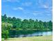 Scenic view of a tranquil pond surrounded by lush green trees under a clear blue sky at 535 Aeolian Dr, New Smyrna Beach, FL 32168