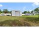 View of home featuring a large metal outbuilding in the expansive, partially shaded lawn at 5984 Ed Harris Ct, St Cloud, FL 34771