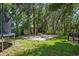 Spacious backyard featuring mature trees, a bench, and a trampoline on a manicured lawn at 672 Seven Oaks Blvd, Winter Springs, FL 32708