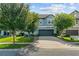 Charming two-story home with a well-manicured lawn and a two-car garage is bathed in natural light against a blue sky at 672 Seven Oaks Blvd, Winter Springs, FL 32708