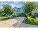 Charming two-story home with a well-manicured lawn and a two-car garage is bathed in natural light against a blue sky at 672 Seven Oaks Blvd, Winter Springs, FL 32708
