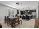Modern kitchen and adjacent dining area featuring sleek black cabinetry, stainless steel appliances, and tile flooring at 672 Seven Oaks Blvd, Winter Springs, FL 32708