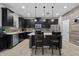 Modern kitchen with black cabinets, stainless steel appliances, and a center island with bar seating at 672 Seven Oaks Blvd, Winter Springs, FL 32708