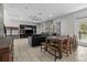Open-concept living space featuring a cozy sectional sofa, dining area, and an outdoor pool view at 672 Seven Oaks Blvd, Winter Springs, FL 32708