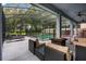 Covered lanai featuring wicker furniture, ceiling fans, and a cozy fire pit overlooking the pool at 672 Seven Oaks Blvd, Winter Springs, FL 32708