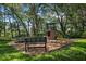 Backyard playground with a tower, slide, swing, and bench surrounded by mature shade trees at 672 Seven Oaks Blvd, Winter Springs, FL 32708