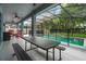 Covered outdoor patio with a dining table and seating overlooking a fenced in pool at 672 Seven Oaks Blvd, Winter Springs, FL 32708