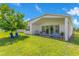 Beautiful backyard with a covered patio, dining set, grill, blue Adirondack chairs, and well maintained lawn at 744 Curly Locks Loop, Apopka, FL 32703