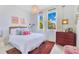 Bright bedroom with decorative pillows, a red dresser, and a large window at 744 Curly Locks Loop, Apopka, FL 32703