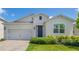 Inviting single-story home with a brick driveway, well-kept lawn, and a welcoming blue front door adorned with a wreath at 744 Curly Locks Loop, Apopka, FL 32703