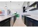 Contemporary kitchen with sleek dark cabinets, stainless steel appliances, and a spacious countertop with modern bar seating at 744 Curly Locks Loop, Apopka, FL 32703