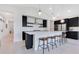Stylish kitchen features sleek, modern cabinetry, stainless steel appliances, a large island with bar seating, and pendant lighting at 744 Curly Locks Loop, Apopka, FL 32703