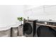 Modern laundry room with front-load machines and storage baskets at 744 Curly Locks Loop, Apopka, FL 32703