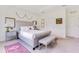 Bright primary bedroom with a tufted headboard, bench, and stylish decor at 744 Curly Locks Loop, Apopka, FL 32703