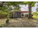 View of the home's large backyard with a screened-in porch, mature trees, and beautiful landscaping that offer privacy and shade at 8040 Sagebrush Pl, Orlando, FL 32822