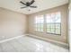 Bright bedroom featuring tile floors, neutral paint, and two windows at 8040 Sagebrush Pl, Orlando, FL 32822