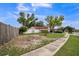 The well-maintained front yard with mature shade trees and beautiful landscaping, and the driveway leads to an attached two-car garage at 8040 Sagebrush Pl, Orlando, FL 32822