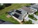 Aerial view of the home with roof-mounted solar panels and a screened-in pool and lanai at 831 Corvina Dr, Davenport, FL 33897