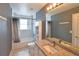 Well-lit bathroom with granite vanity, large mirror, bathtub, and tiled walls at 831 Corvina Dr, Davenport, FL 33897