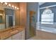 Elegant bathroom with granite-topped vanity, glass shower, and a large bathtub with window at 831 Corvina Dr, Davenport, FL 33897