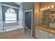 Bright main bathroom features a granite-topped vanity and a large bathtub with natural light at 831 Corvina Dr, Davenport, FL 33897