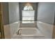 Close up of a bathtub with white marble tile and a window at 831 Corvina Dr, Davenport, FL 33897