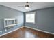 Cozy bedroom with ceiling fan, built-in desk, window with blinds, and dark hardwood floors at 831 Corvina Dr, Davenport, FL 33897