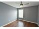 Calming bedroom with ceiling fan, window with blinds, and dark hardwood floors at 831 Corvina Dr, Davenport, FL 33897