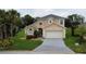 Inviting two-story home with well-manicured lawn and attached two car garage on a sunny day at 831 Corvina Dr, Davenport, FL 33897