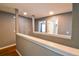 Well-lit hallway with hardwood floors and neutral gray walls, leading to various rooms at 831 Corvina Dr, Davenport, FL 33897
