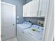 Laundry room with washer, dryer, and white cabinets at 831 Corvina Dr, Davenport, FL 33897