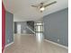 Spacious living room with tile flooring, connecting to the entryway and staircase at 831 Corvina Dr, Davenport, FL 33897
