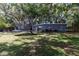 Backyard featuring lush greenery, a trampoline, patio area, and a charming grey home exterior at 845 Edgewater Cir, Eustis, FL 32726