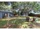 Backyard featuring a lush green lawn, trampoline, patio seating, and a privacy fence at 845 Edgewater Cir, Eustis, FL 32726