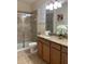Well-lit bathroom features granite countertops, dual sinks, a glass-enclosed shower, and decor at 8894 Candy Palm Rd, Kissimmee, FL 34747