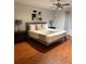 Cozy bedroom featuring hardwood floors, queen-sized bed with decorative pillows, ceiling fan, and dark wood nightstands at 8894 Candy Palm Rd, Kissimmee, FL 34747