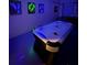Game room has an air hockey table and unique neon art, ideal for entertainment at 8894 Candy Palm Rd, Kissimmee, FL 34747