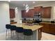 Modern kitchen with granite countertops, stainless steel appliances, island with barstool seating, and ample cabinet space at 8894 Candy Palm Rd, Kissimmee, FL 34747