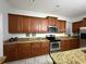Well-appointed kitchen featuring granite countertops, stainless steel appliances, and beautiful wooden cabinets at 8894 Candy Palm Rd, Kissimmee, FL 34747