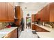 Bright kitchen features wooden cabinetry, mosaic backsplash, stainless appliances, and white marbled tile floor at 9326 Bay Vista Estates Blvd, Orlando, FL 32836