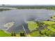 Scenic aerial view of a large lake with a boat dock and lush green surroundings and cityscape in background at 9326 Bay Vista Estates Blvd, Orlando, FL 32836