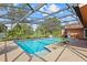 Screened-in pool area featuring a sparkling blue pool, concrete decking, and serene backyard views at 9326 Bay Vista Estates Blvd, Orlando, FL 32836