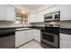 Bright kitchen with white cabinets, stainless steel appliances, and a window view at 940 Douglas Ave # 132, Altamonte Springs, FL 32714