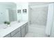 Bright bathroom featuring a single vanity, marble tile accents, and a bathtub with shower at 976 Leader St, Davenport, FL 33896