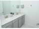 Bright bathroom featuring a double vanity with gray cabinets and modern fixtures at 976 Leader St, Davenport, FL 33896