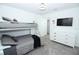 Neutral bedroom with a bunkbed, sleek dresser, and mounted television at 976 Leader St, Davenport, FL 33896