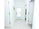 Bright hallway with marble tile floors and white doors leading to various rooms at 976 Leader St, Davenport, FL 33896