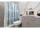 Bright bathroom with a shower/tub combo, a modern vanity, and a decorative seashell shower curtain at 9814 Piney Point Cir, Orlando, FL 32825